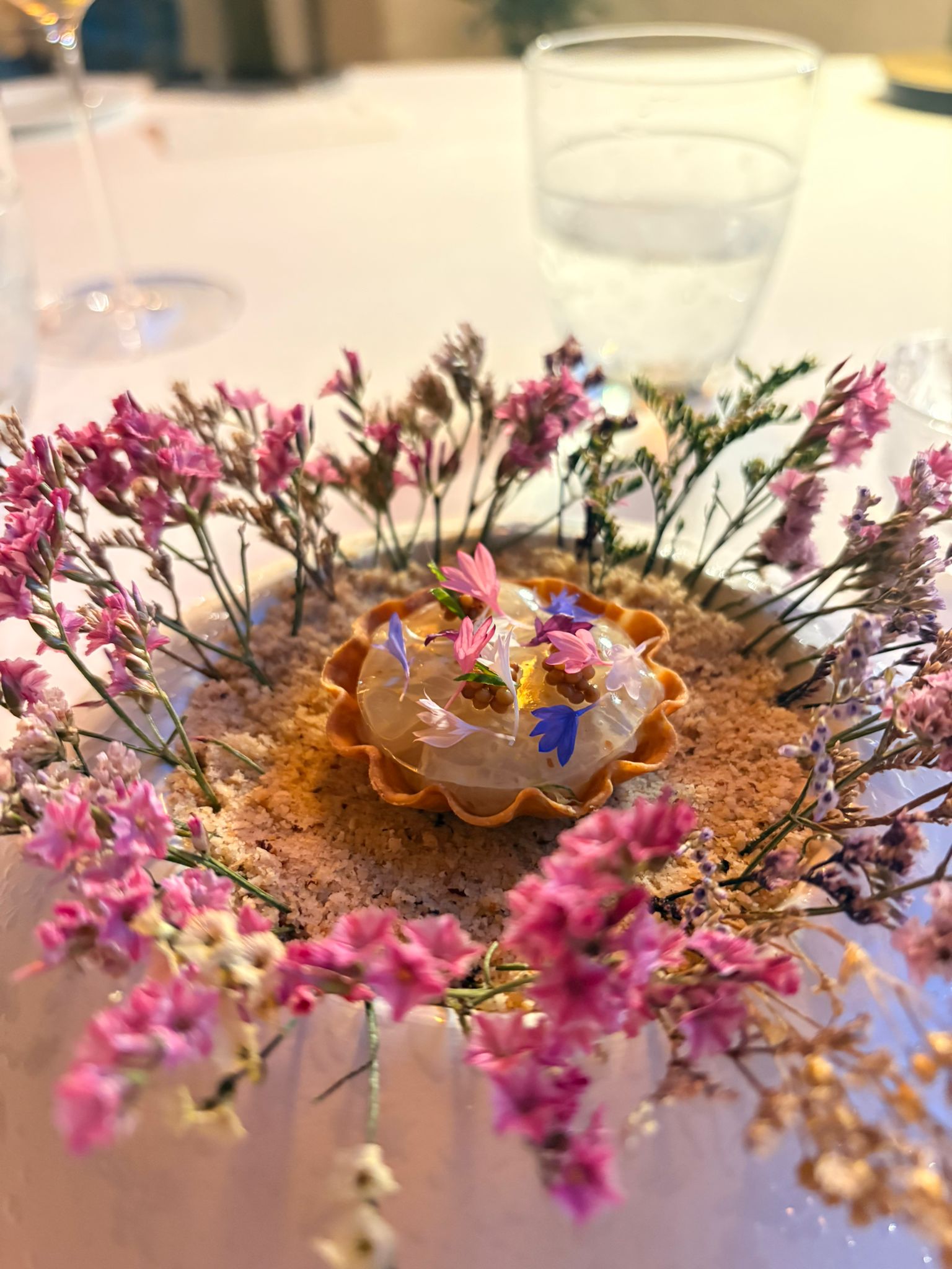 Una portata di Alessandro Cozzolino incorniciata da fiori